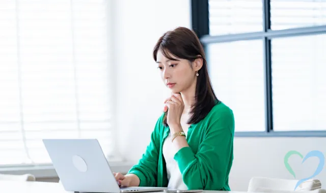 パソコンを使って自力で情報収集をする女性